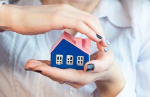 hands hold carefully a small house,