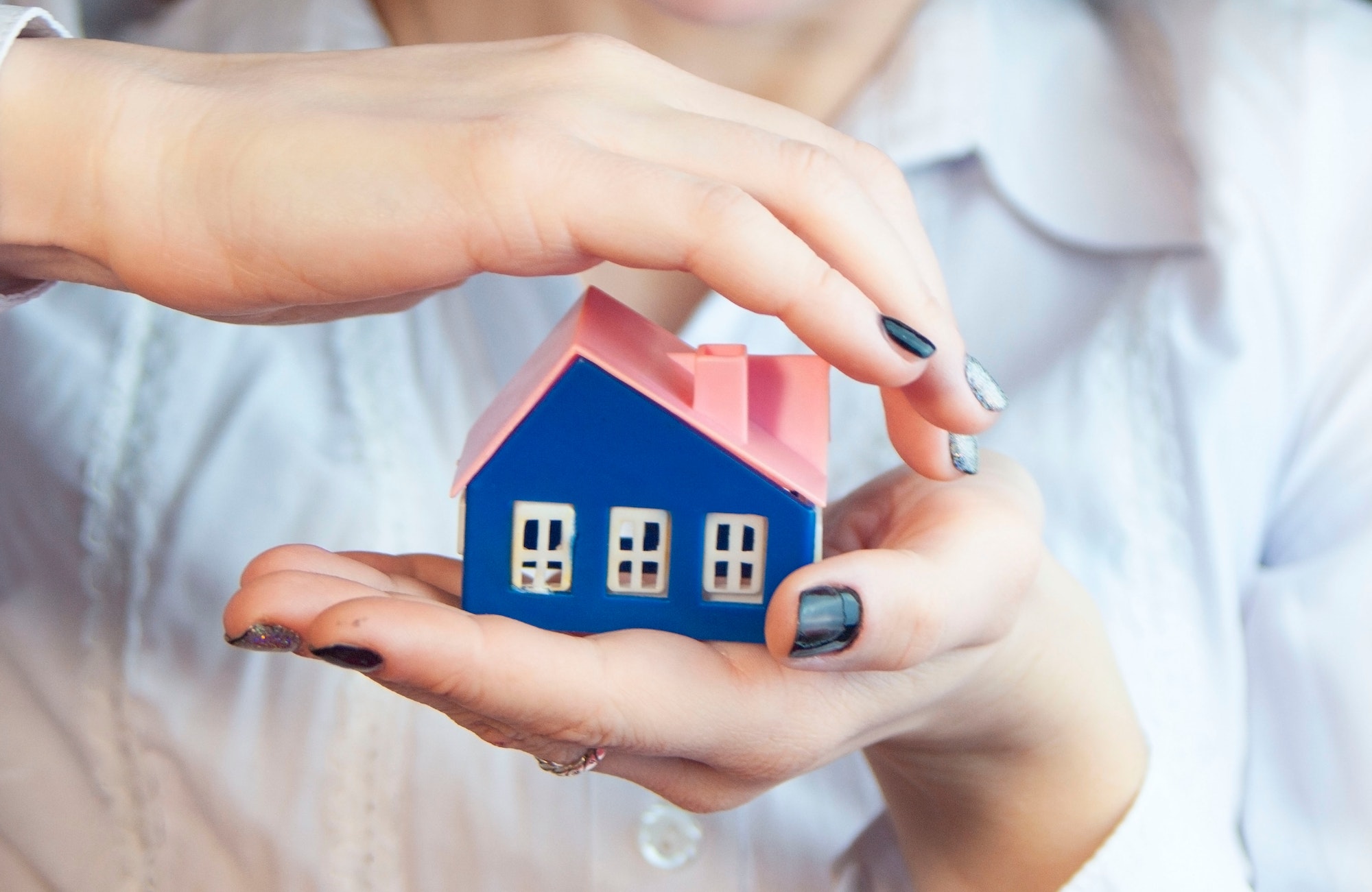 hands hold carefully a small house,